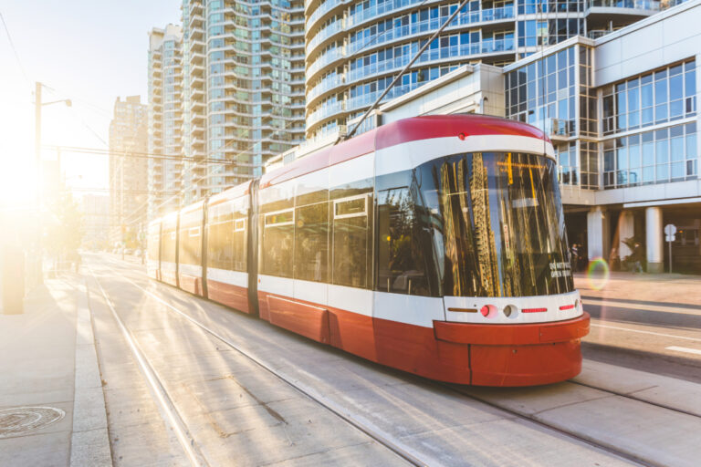 Modern tram in Toronto downtown at sunset. There is no traffic in the road, and nobody on the platform. Travel and transportation concepts.